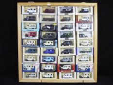 Lledo - 32 diecast model ambulances by Lledo contained within a wooden display cabinet measuring