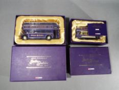 Corgi - two boxed setscomprising a double decker bus and an open top tram commemorating the Queen