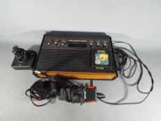 Atari - An Atari 2600 (wood veneer version) with controllers and Pac-Man game cartridge.