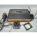 Atari - An Atari 2600 (wood veneer version) with controllers and Pac-Man game cartridge.