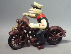 A cast iron model depicting Popeye riding a motorcycle, approximately 16.