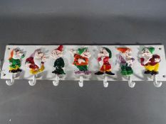 A cast iron coat rack decorated with the seven dwalfs (xcr7d)