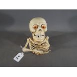 A cast iron novelty money bank depicting a skeleton (xbskl)