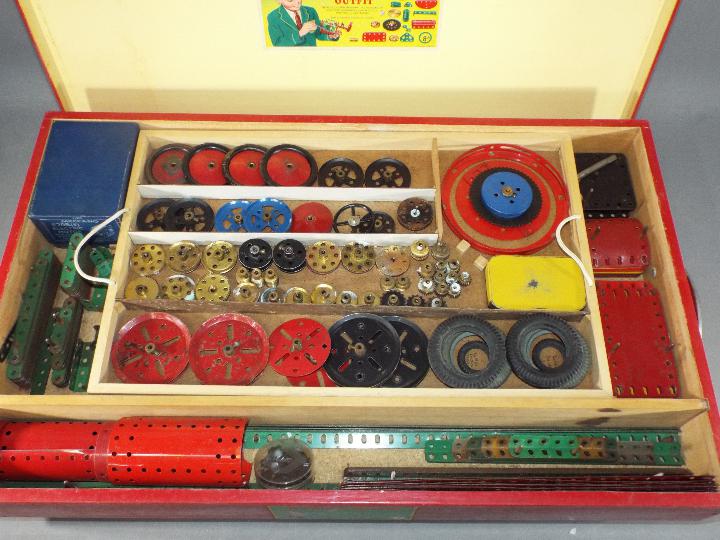 Meccano - A vintage Meccano set 7A presented in a red wooden box on castors with a lift off lid and