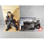 A DC Justice League Batmobile by Mattell FGG58 and a WWE action figure of Roman Reigns, both boxed.