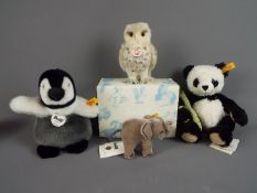 Steiff - four Steiff animals comprising Manschli Panda with tags and button in ear with yellow