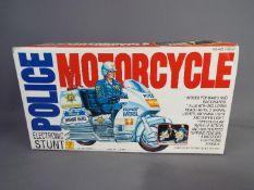 Min Yin - A vintage boxed plastic Police Electronic Stunt Motorcycle by Min Yin Toys .