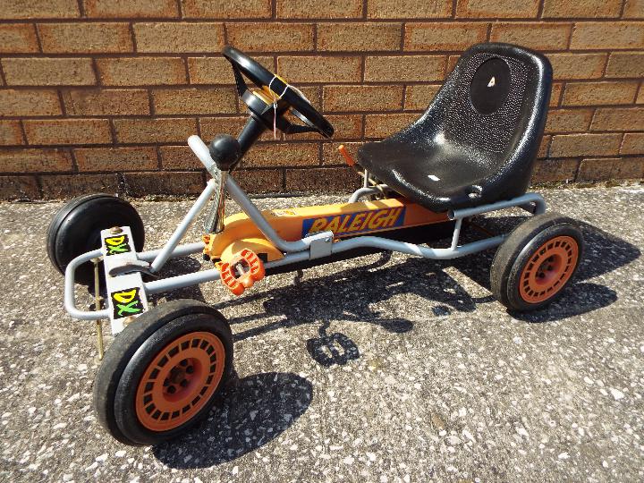 A vintage children's Raleigh DX Go-Kart in orange,