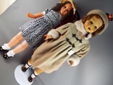 Dolls - A pair of tall walking dolls consisting of a female brunette doll with a composition face,