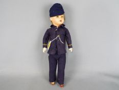SFBJ Jumeau - A SFBJ composition faced boy doll dressed in a blue felt uniform with metal buttons,