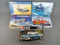 Five boxed model kits in varying scales by Tamiya, Revell,