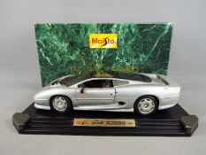 A boxed 1:12 scale Jaguar XJ220 (1992) in silver, model appears in VG condition but dusty, box VG.