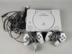 Sony - An unboxed Sony Playstation console with power supply and two controllers.