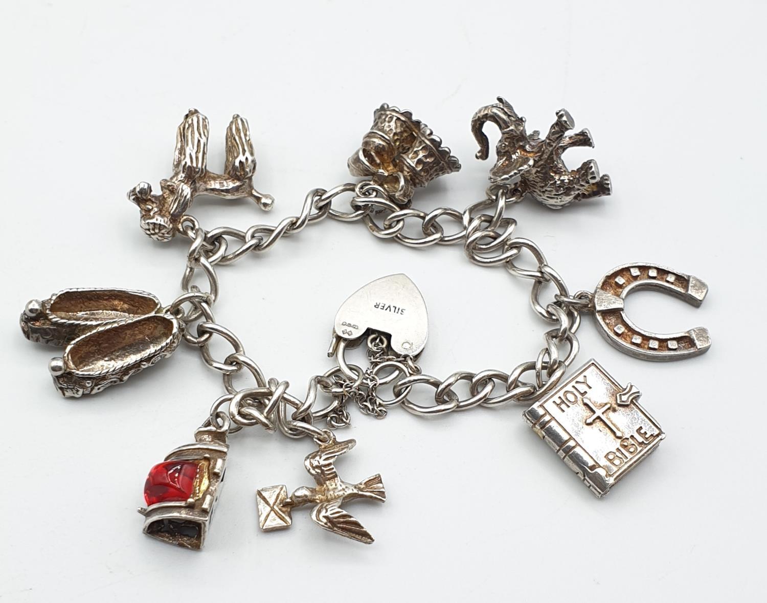 Silver charm bracelet with 8 charms and heart clasp, weight 35.6g