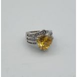 Stone set silver ring with large triangular citrine coloured stone. Rows of zircons to shoulders