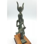 A small copper statue of the Egyptian Goddess 'ISIS' holding her son Horus on wooden plynth, 20cm
