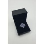 silver and tanzanite stone set ring having 19 stones in a floral cluster form. showing 925 for