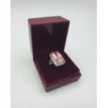 Stone Set Silver Ring with a large rectangular pink stone bordered by 24 zirconias inside the silver