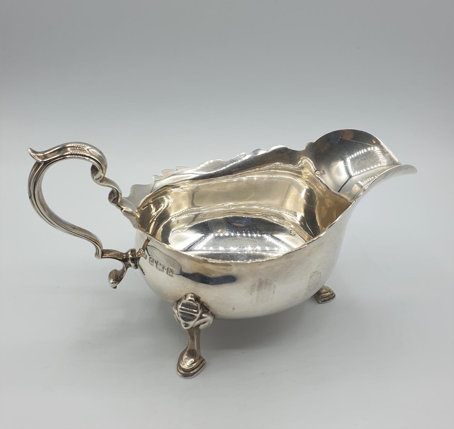 Antique Silver Sauce/ Gravy boat with three cabriole legs and having an unusual scale design to