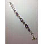 Stone set silver and amethyst bracelet, having seven stones individually mounted each with a