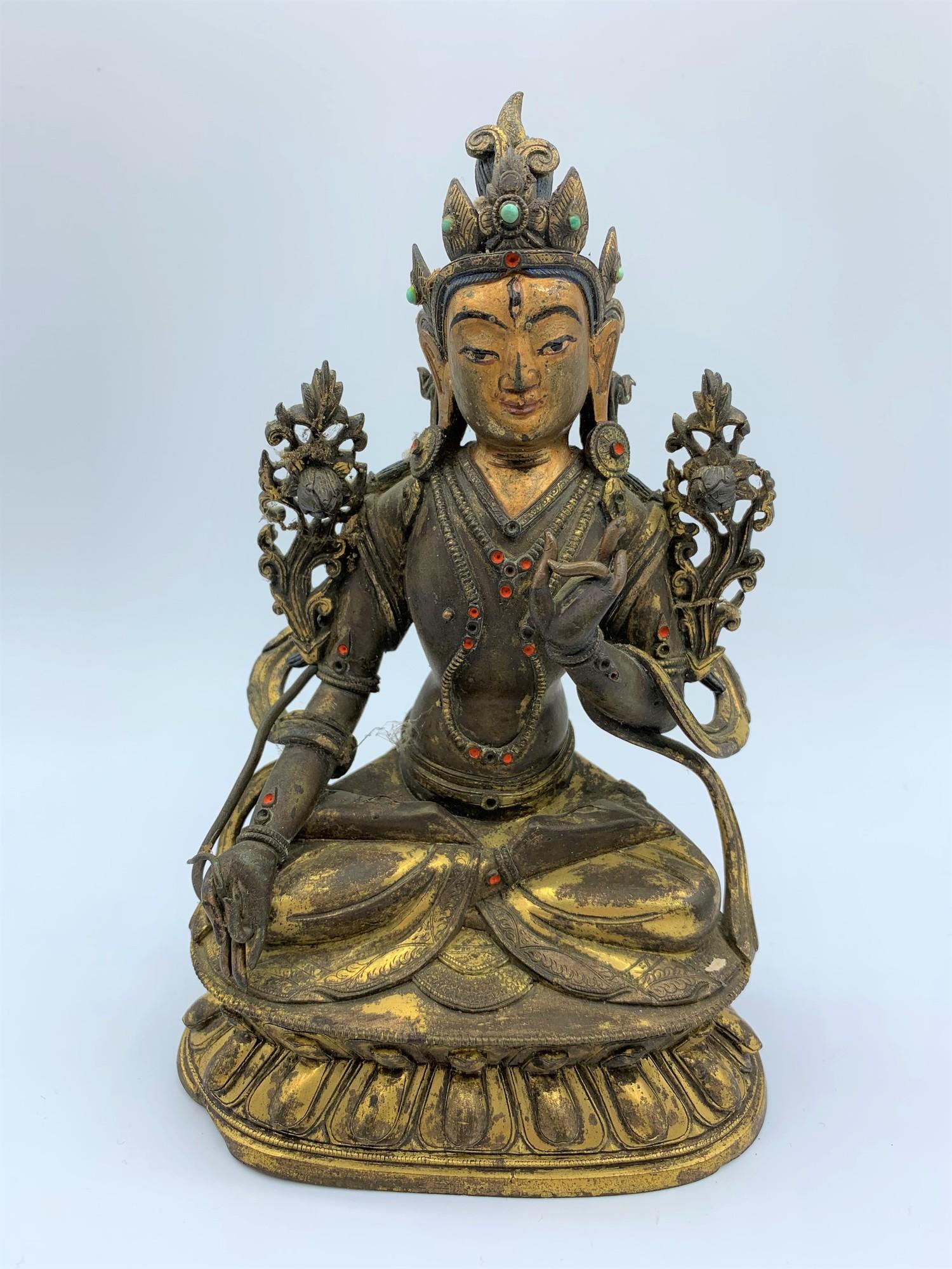 A very early Tibetan religious deity gilt on bronze with turquoise stones and painted dace, weight