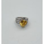 Stone set silver ring with large triangular citrine coloured stone. Rows of zircons to shoulders