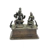 Oriental figures seated on a plinth in bronze, 8.5cm tall and 8cm wide, weight 220g approx