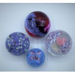 4 ball shaped heavy glass paperweights.