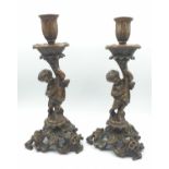 A pair of ornate bronze candle sticks with cherub, 2.9kg