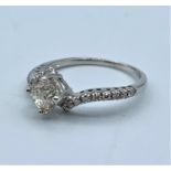 18ct white gold diamond encrusted crossover ring with 0.65ct centre stone, weight 2.3g and size M