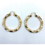 A pair of yellow metal large twist hoop earrings. Which weighs 13.6g.