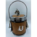 Vintage ice bucket having a horses head to lid and stirrups to sides. Covered in faux leather and