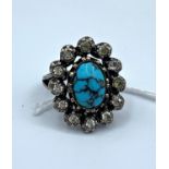 A vintage silver ring with turquoise stone surrounds with small C.2 stones. It weighs 7.8g and the