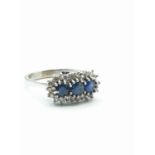 18ct white gold ring with sapphire trilogy and diamond surround, sapphires total 1ct and diamond