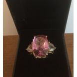 Stone set silver ring semi-transparent, having a large rectangular pink cushion cut stone with two