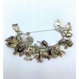 Silver charm bracelet with padlock catch & 20 pin charms, it is 16cms long and weighs 69g.