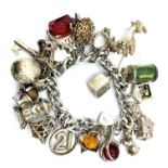 A silver charm bracelet with 21 interesting charms and padlock catch. It weighs 131g and the