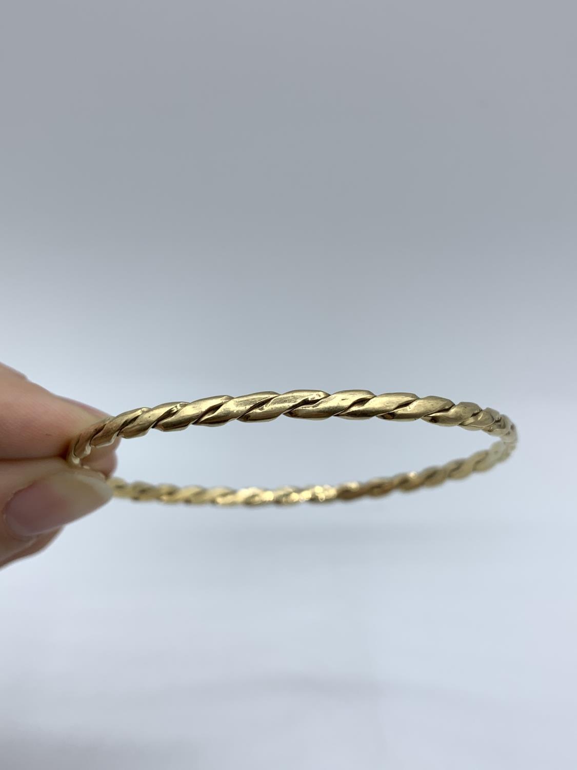 A yellow metal (tested as 9ct gold) twisted bangle, weight 9.5g approx - Image 3 of 3