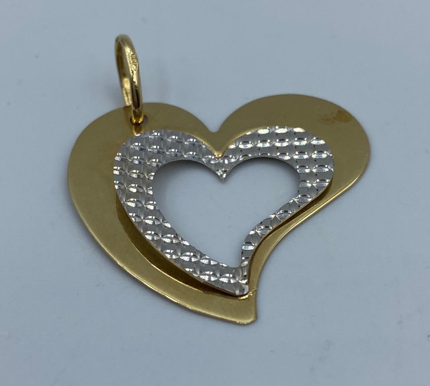 Large heart shaped pendant set in 14k yellow and white gold in modern design, weight 2.24g and