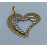 Large heart shaped pendant set in 14k yellow and white gold in modern design, weight 2.24g and