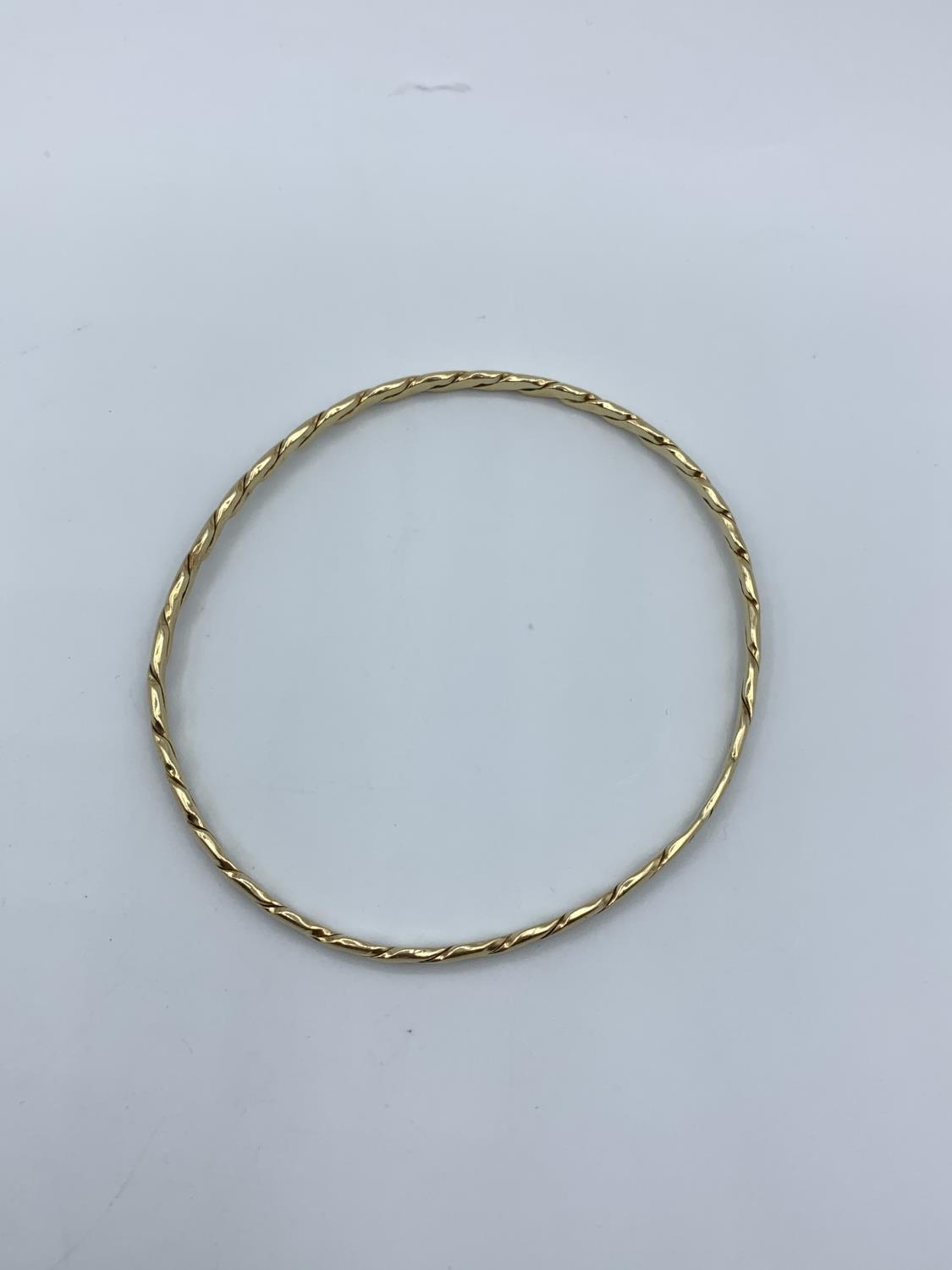 A yellow metal (tested as 9ct gold) twisted bangle, weight 9.5g approx - Image 2 of 3