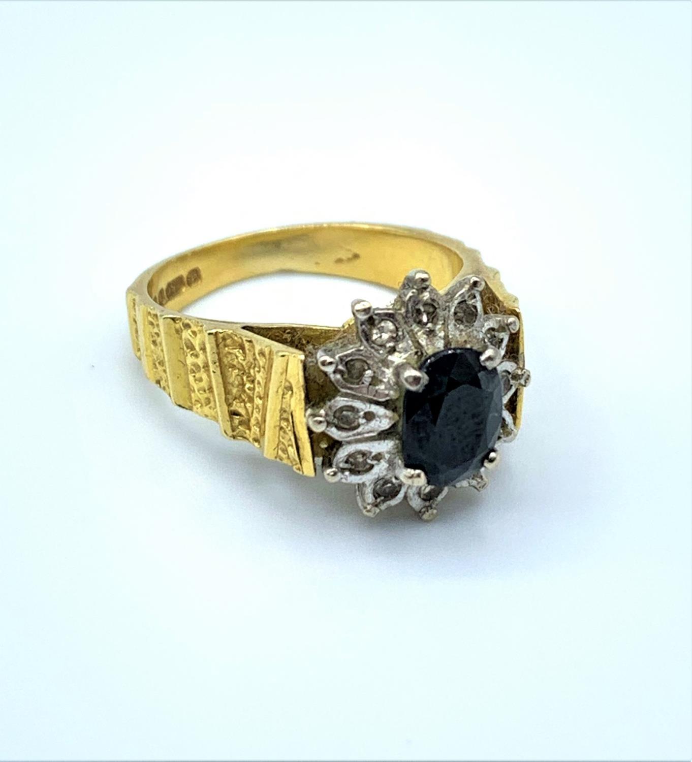 18ct yellow gold ring with grooved shoulders and claw set black centre surrounded by small diamonds,