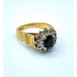18ct yellow gold ring with grooved shoulders and claw set black centre surrounded by small diamonds,