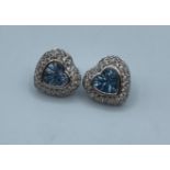 Pair of 14k white gold heart shaped earrings with centre blue topaz and encrusted CZ stones