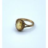 A vintage 9ct dress ring with yellow stone. Weighs 2.3g, size L.