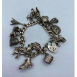 Silver Charm Bracelet having 16 Charms plus a silver padlock, charms to include Eiffel Tower,