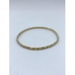 A yellow metal (tested as 9ct gold) twisted Bangle, weight 9.5g approx