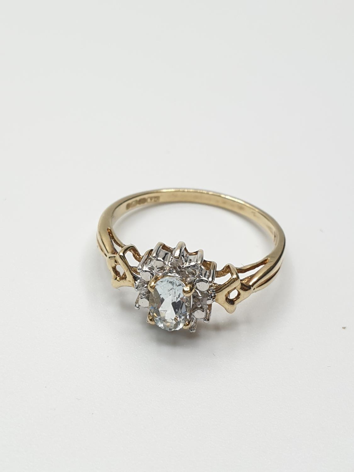 Stone set 9ct Yellow gold Ring having an oval Topaz to centre of mount with a surround of small