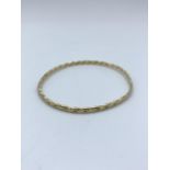 A yellow metal (tested as 9ct gold) twisted Bangle, weight 9.5g approx