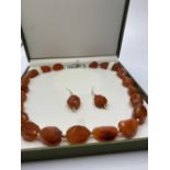 A large beaded carnelian necklace and matching earrings (beads up to 36mm) Total weight 152g. In a